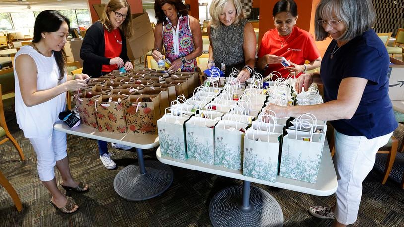 This team of ladies, From left, Tam Dowd, Community Gem Karen Westgerdes, Rene' Chase, Stephanie Singer, Rekha Vira and Pam Berg, pack street bangs at Lexis Nexis. The bags are made to help women on the streets and to combat sexual trafficking. MARSHALL GORBY/STAFF