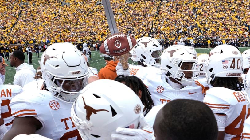 Texas defensive back Andrew Mukuba celebrates his interception with the turnover sword against Michigan in the first half of an NCAA college football game in Ann Arbor, Mich., Saturday, Sept. 7, 2024. (AP Photo/Paul Sancya)