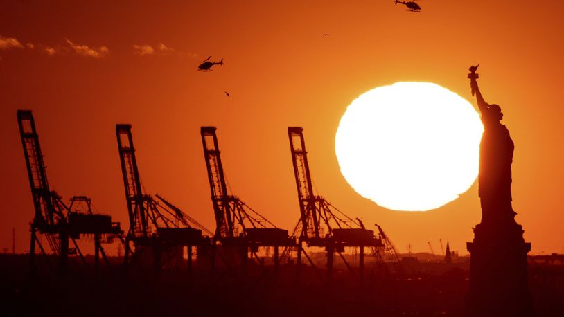 FILE - Cranes at the Port of New York and New Jersey appear behind the Statue of Liberty, Nov. 20, 2022, in a photo taken from New York. (AP Photo/Julia Nikhinson, File)