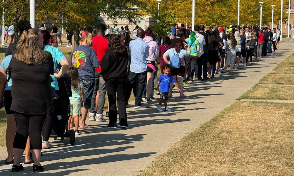 Parents wait in line at Springfield High School to pick up Simon Kenton Elementary students Monday. BILL LACKEY/STAFF