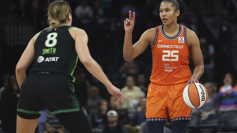 Connecticut Sun forward Alyssa Thomas (25) handles the ball against Minnesota Lynx forward Alanna Smith (8) during the second half of Game 1 of a WNBA basketball semifinals series Sunday, Sept. 29, 2024, in Minneapolis. (AP Photo/Stacy Bengs)