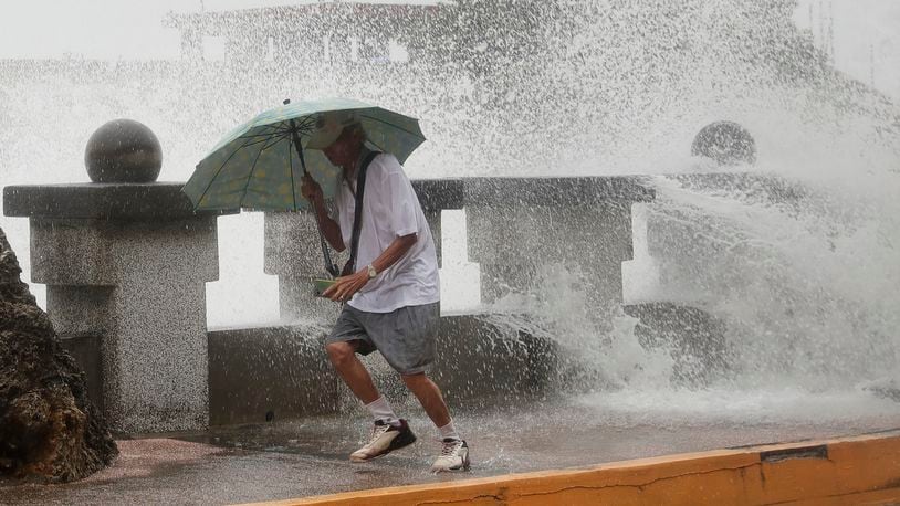 A man runs away from waves when he was walking along the shore in Kaohsiung, Southern Taiwan, Wednesday, Oct. 2, 2024, as Typhoon Krathon is expected to hit the area. (AP Photo/Chiang Ying-ying)