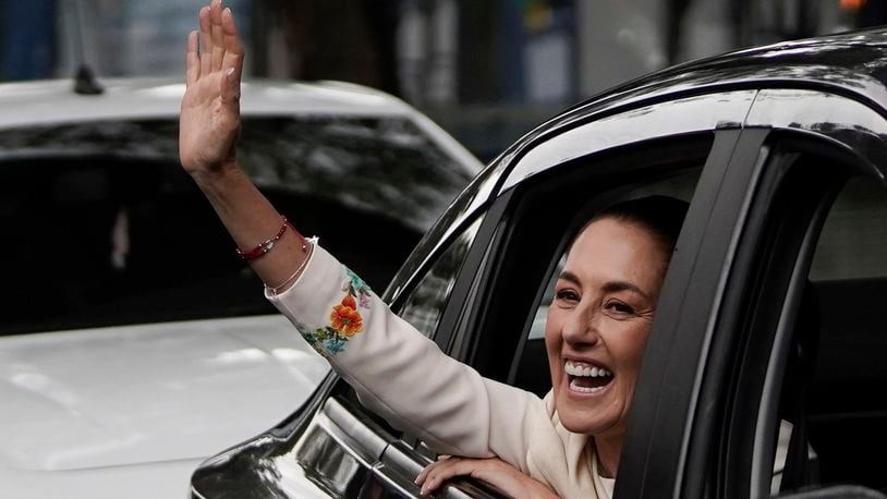 Claudia Sheinbaum waves from the vehicle taking her to Congress to assume the presidency in Mexico City, Tuesday, Oct. 1, 2024. (AP Photo/Aurea Del Rosario)