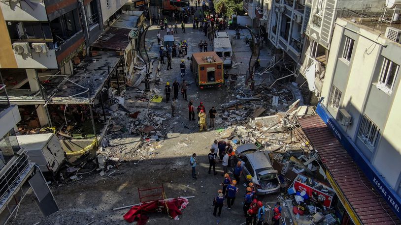 Firefighters and emergency team members work during the aftermath of an explosion in a restaurant in Izmir, western Turkey, Sunday, June 30, 2024. Turkish authorities say a propane tank explosion at a restaurant in the western city of Izmir has left at least five people dead and over 60 others injured. Security cameras recorded the explosion on Sunday that devastated the street and caused minor damage to surrounding buildings. (Mustafa Ic/IHA via AP)