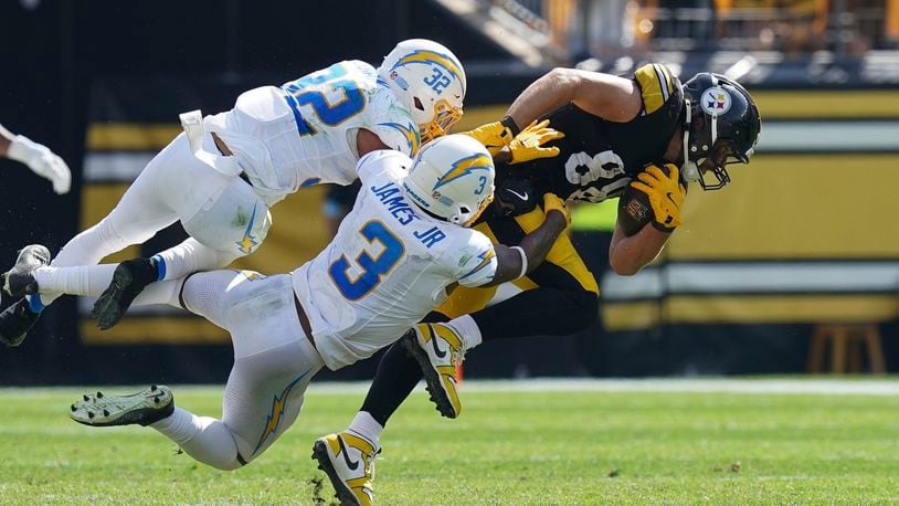 Pittsburgh Steelers tight end Pat Freiermuth, right, is tackled by Los Angeles Chargers safeties Alohi Gilman (32) and Derwin James Jr. during the second half of an NFL football game, Sunday, Sept. 22, 2024, in Pittsburgh. (AP Photo/Matt Freed)