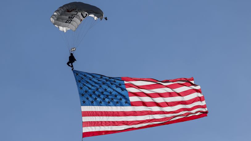 A parade featuring 100 combat-injured warriors and fallen hero families will make its way through Miamisburg Aug. 10 and culminate with flag jumps by Team Fastrax. This photo highlights a similar jump made during the Ohio Challenge Hot Air Balloon and Skydiving Festival Friday, July 19, 2024 at Smith Park in Middletown. NICK GRAHAM/STAFF