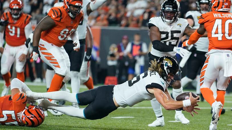 Jacksonville Jaguars quarterback Trevor Lawrence (16) dives in for touchdown while being tackled by Cincinnati Bengals' Logan Wilson (55) during the first half of an NFL football game, Thursday, Sept. 30, 2021, in Cincinnati. (AP Photo/Michael Conroy)