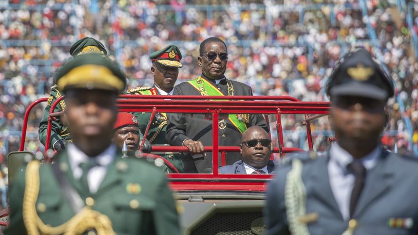 Zimbabwean President Emmerson Mnangagwa, centre, inspects a guard of honour from a military truck during the 44th Zimbabwe Defence Forces Day comemmorations at Rufaro Stadium in Harare, Tuesday Aug. 13, 2024. (AP Photo/Aaron Ufumeli)