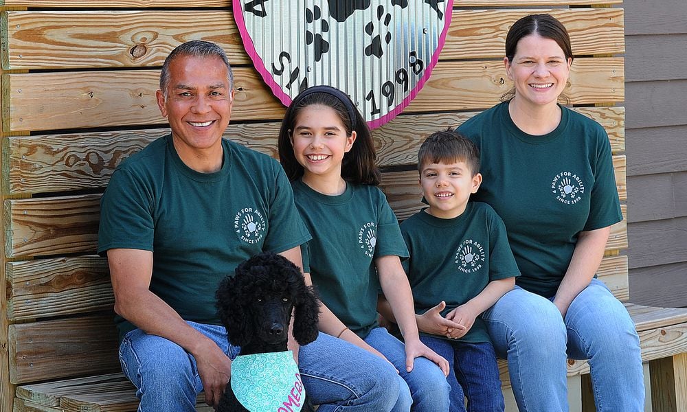 The Tibuni Family, from left, Daniel, Emerson, age 10, Branson, age 6, and Kandice, and sitting in front is 2-year-old Tamera, a standard Poodle. The family all volunteer at 4 Paws For Ability in Xenia. MARSHALL GORBY\STAFF