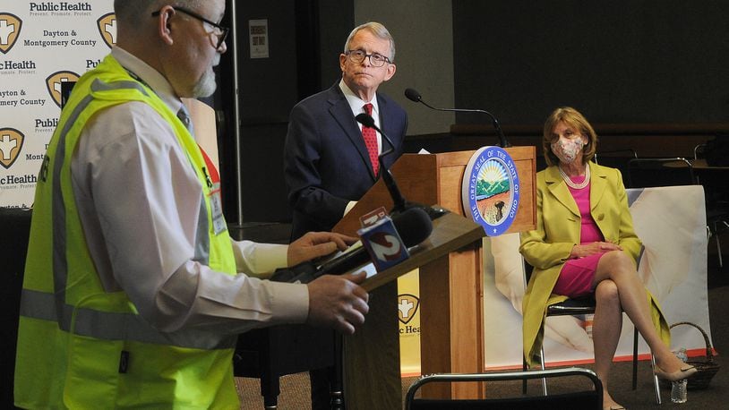 Jeff Cooper, health commissioner for Public Health Dayton Montgomery County, talks with Ohio governor Mike DeWine and first lady Fran DeWine at the Dayton Convention Center Thursday, April 1, 2021. MARSHALL GORBY\STAFF