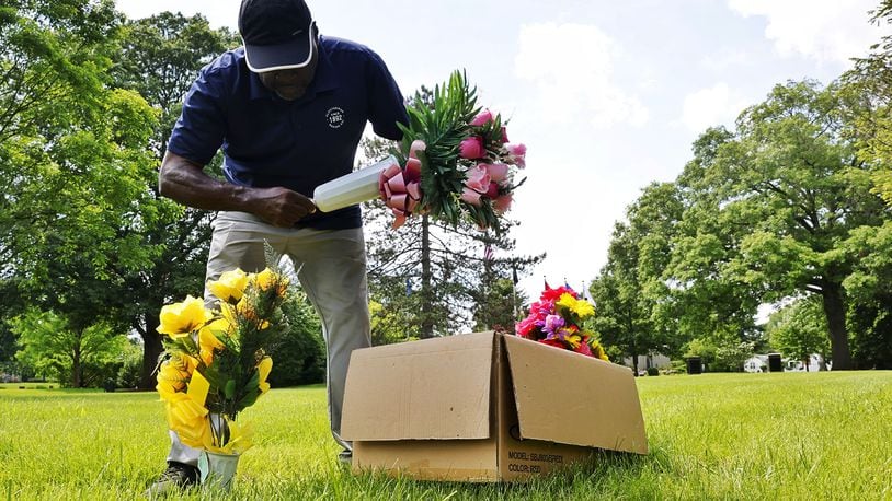 Orlando Moore places flowers at the graves of his uncles who served in various branches of military ahead of Memorial Day Tuesday, May 21, 2024 st Woodside Cemetery and Arboretum in Middletown. NICK GRAHAM/STAFF