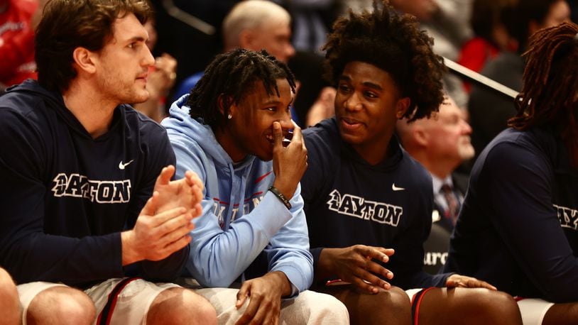 Dayton's Malachi Smith, second from left, talks to Marvel Allen during a game against Longwood on Saturday, Dec. 30, 2023, at UD Arena. David Jablonski/Staff