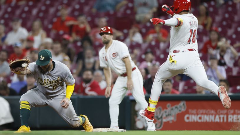 Oakland Athletics first baseman Seth Brown, left, catches the ball to get Cincinnati Reds' Noelvi Marte out at first base during the eighth inning of a baseball game, Tuesday, Aug. 27, 2024, in Cincinnati. (AP Photo/Jay LaPrete)