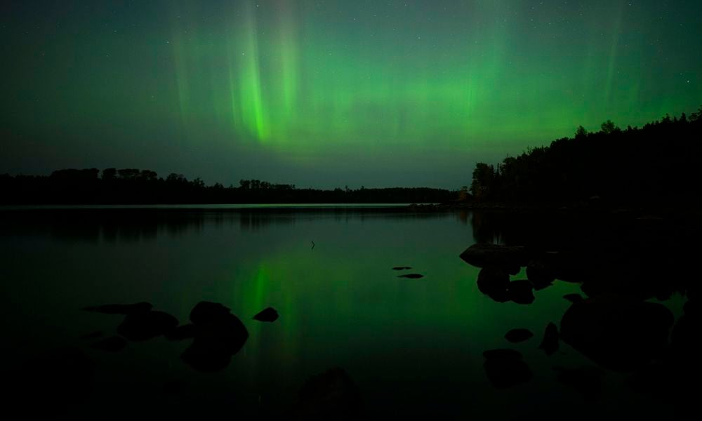 The northern lights, or aurora borealis, are visible in the sky north of the Fall Lake Campground Thursday, Sept. 12, 2024 just outside the Boundary Waters Canoe Area Wilderness in Ely, Minn. (Aaron Lavinsky/Star Tribune via AP)