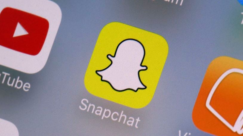 FILE - The Snapchat app on a mobile device is seen in New York. Snap Inc., Wednesday, Aug. 9, 2017. The owner of Snapchat will pay $15 million to settle a lawsuit brought by California’s civil rights agency that claimed the company discriminated against female employees, failed to prevent workplace sexual harassment and retaliated against women who complained. (AP Photo/Richard Drew, File)