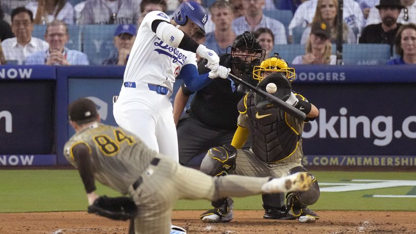 Los Angeles Dodgers' Shohei Ohtani, middle left, connects for a three-run home run off San Diego Padres starting pitcher Dylan Cease (84) during the second inning in Game 1 of baseball's NL Division Series, Saturday, Oct. 5, 2024, in Los Angeles. (AP Photo/Mark J. Terrill)