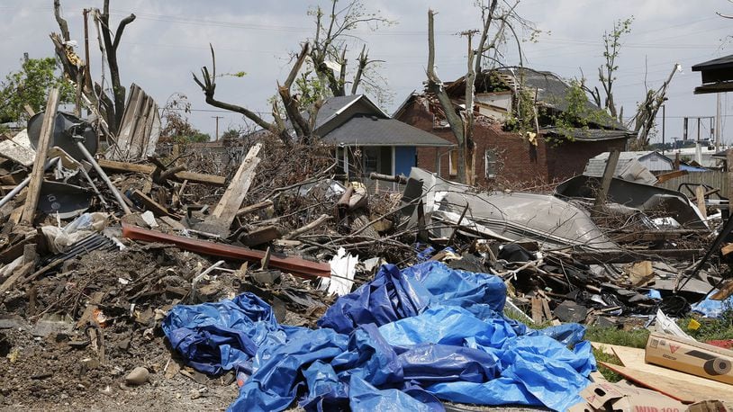 Mounds of tornado strewn debris are piled behind houses and apartments on Troy Street and Kelly Avenue. Repairs are underway or waiting for insurance settlements in communities throughout the Dayton area one month after the Memorial Day tornadoes tore through many neighborhoods. TY GREENLEES / STAFF
