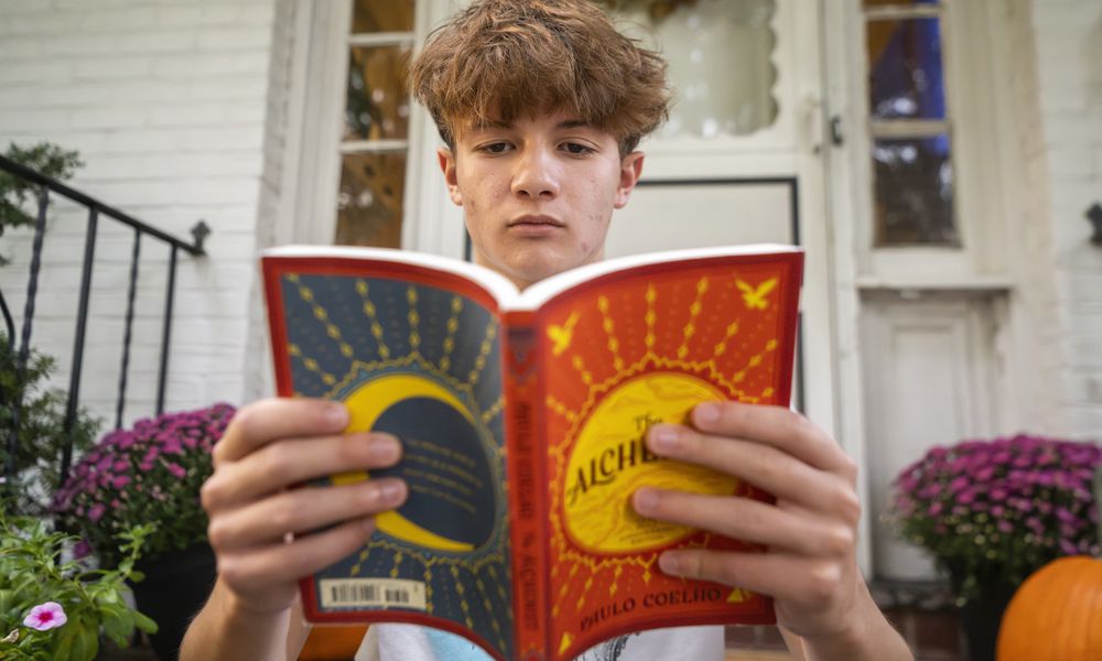 Chris Stanislawski, 14, poses for a portrait outside of his home in Garden City, N.Y., on Friday, Sept. 13, 2024. Chris didn't finish any books in his 8th grade English class, in part because their google classroom had detailed summaries of each chapter of every book. (AP Photo/Brittainy Newman)