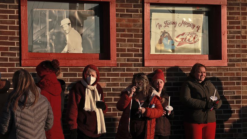 Family, friends and community members fill the parking lot of Gill's Quality Meat Market Monday, Jan. 9, 2023 before the start of a candlelight vigil for Thomas Gill, who was shot and killed last Thursday while driving his SUV in Springfield. BILL LACKEY/STAFF