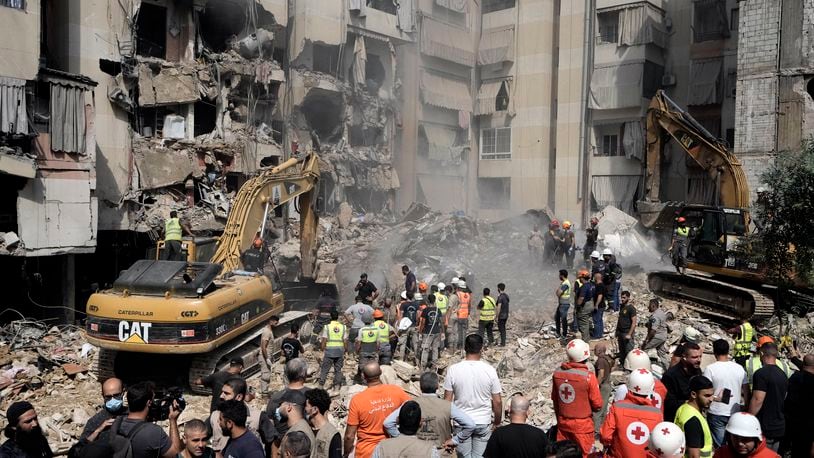 Emergency workers use excavators to clear the rubble at the site of Friday's Israeli strike in Beirut's southern suburbs, Saturday, Sept. 21, 2024. (AP Photo/Bilal Hussein)