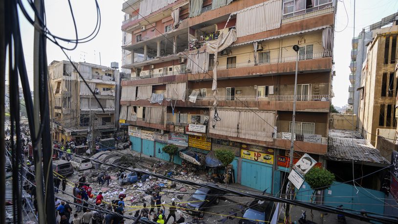 Residents and rescuers check a building that was hit by an Israeli airstrike in Beirut's southern suburbs, Tuesday, Sept. 24, 2024. (AP Photo/Hassan Ammar)