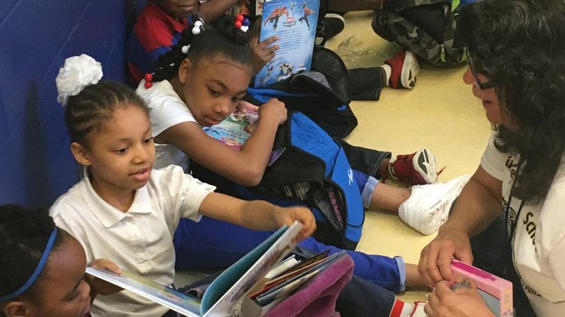 Third-graders at Fairview School in Dayton check out new books in May 2016, courtesy of the Read On program. JEREMY P. KELLEY/STAFF