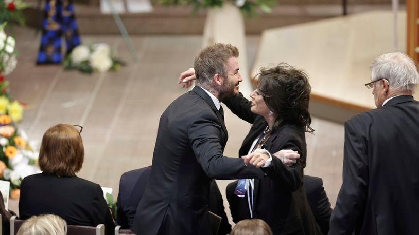 David Beckham and Nancy Dell'Olio hug as they arrive to attend the funeral service of Swedish soccer manager Sven-Goran Eriksson at Fryksände church in Torsby, Sweden, Friday Sept. 13, 2024. (Adam Ihse/TT News Agency via AP)