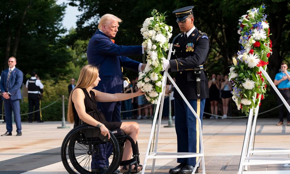 Former U.S. Marine Corps Cpl. Kelsee Lainhart left, and Republican presidential nominee former President Donald Trump place a wreath at the Tomb of the Unknown Solider in honor of the 13 service members killed at Abbey Gate, at Arlington National Cemetery, Monday, Aug. 26, 2024, in Arlington, Va. (AP Photo/Alex Brandon)