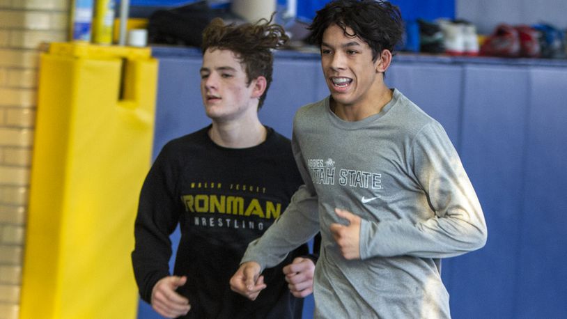 Legacy Christian junior Dillon Campbell, right, runs laps in the team's wrestling room Monday alongside freshman Nathan Attisano. Both are competing in the Division III state wrestling tournament this weekend, and Campbell is going for his third straight state title. CONTRIBUTED/Jeff Gilbert