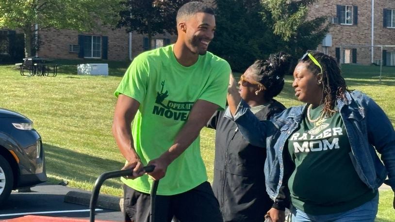 Volunteers helped unload cars and move students into residence halls as Debra Radford, left and Franchesca Alford, right, cheered for them on Wednesday morning. Eileen McClory/ staff