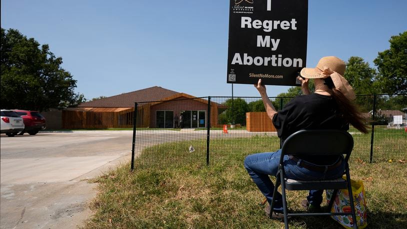 Anti-abortion protester Deborah Green-Myers, from Pittsburg, Kan., demonstrates outside a recently opened Planned Parenthood clinic, Tuesday, Sept. 10, 2024, in Pittsburg, Kan. (AP Photo/Charlie Riedel)