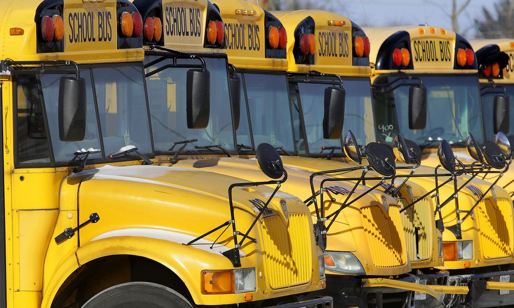 FILE - Public school buses are parked in Springfield, Ill., on Jan. 7, 2015. (AP Photo/Seth Perlman, File)