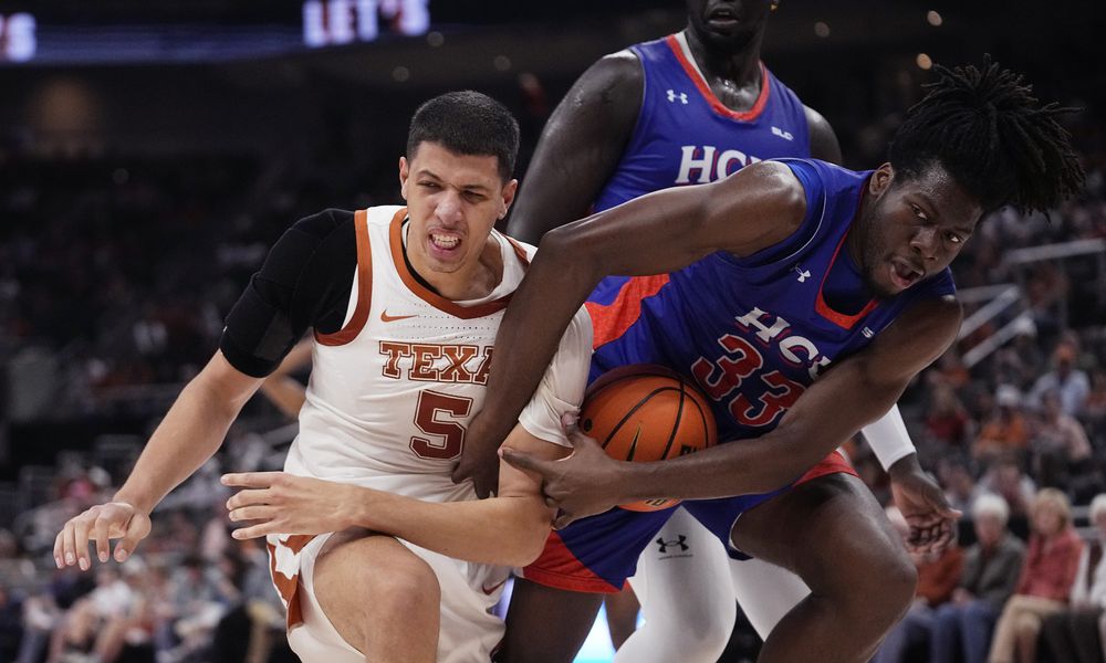 Texas forward Kadin Shedrick (5) and Houston Christian forward Michael Imariagbe (33) fight for control of the ball during the second half of an NCAA college basketball game in Austin, Texas, Saturday, Dec. 9, 2023. (AP Photo/Eric Gay)