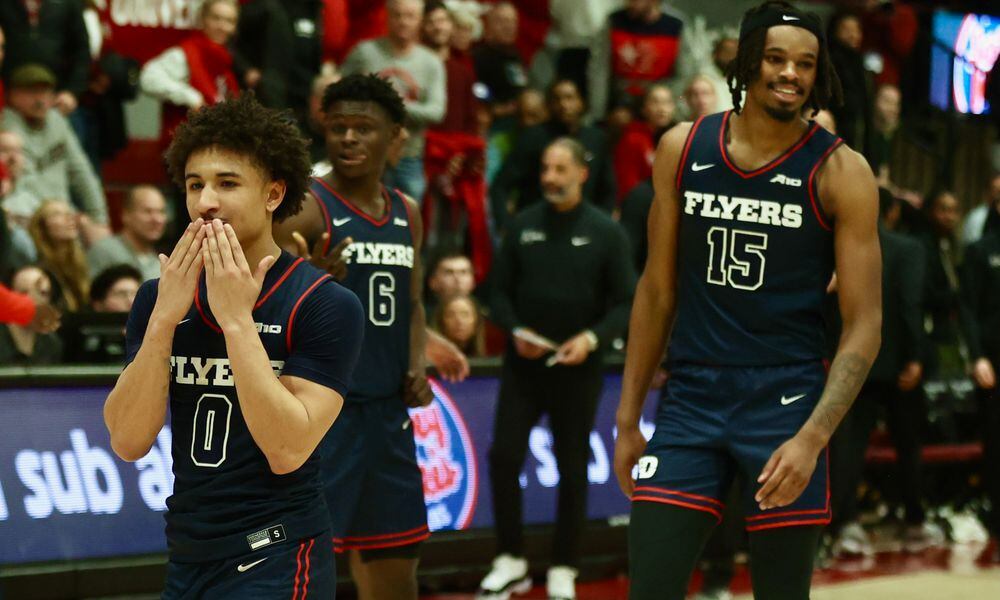 Dayton's Javon Bennett, left, and DaRon Holmes II celebrate a victory against Saint Josephs on Tuesday, Feb. 6, 2024, at Hagan Arena in Philadelphia. David Jablonski/Staff