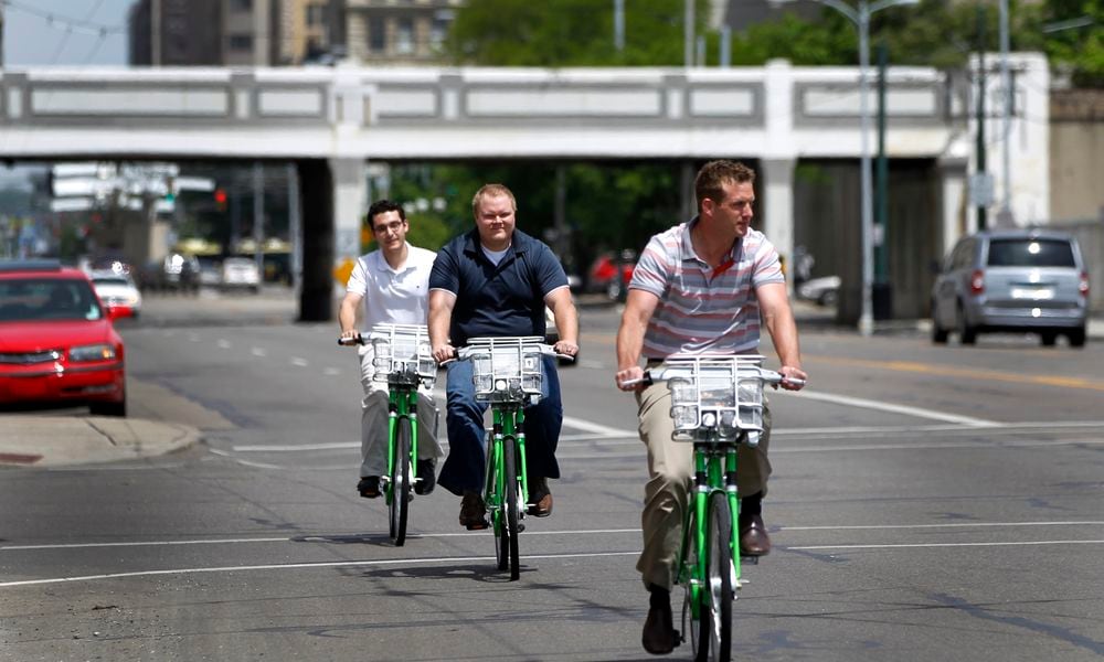 Eric Wright, Chris Lialios and Stetson Blake (front to rear) checked out bicycles from the Link Dayton Bike Share in downtown Dayton to ride from their office to Brown Street to have lunch. LISA POWELL / STAFF 2015 FILE PHOTO