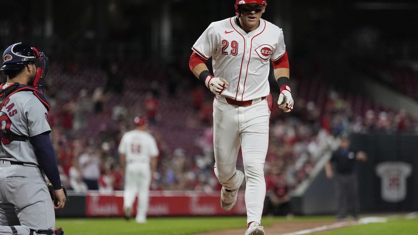 Cincinnati Reds' TJ Friedl crosses home plate after hitting a solo home run during the seventh inning of a baseball game against the St. Louis Cardinals, Wednesday, Aug. 14, 2024, in Cincinnati. St. Louis Cardinals catcher Willson Contreras is left. (AP Photo/Carolyn Kaster)