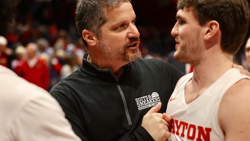 Dayton trainer Mike Mulcahey and Brady Uhl leave the court after a victory against Richmond on Saturday, Jan. 28, 2023, at UD Arena. David Jablonski/Staff