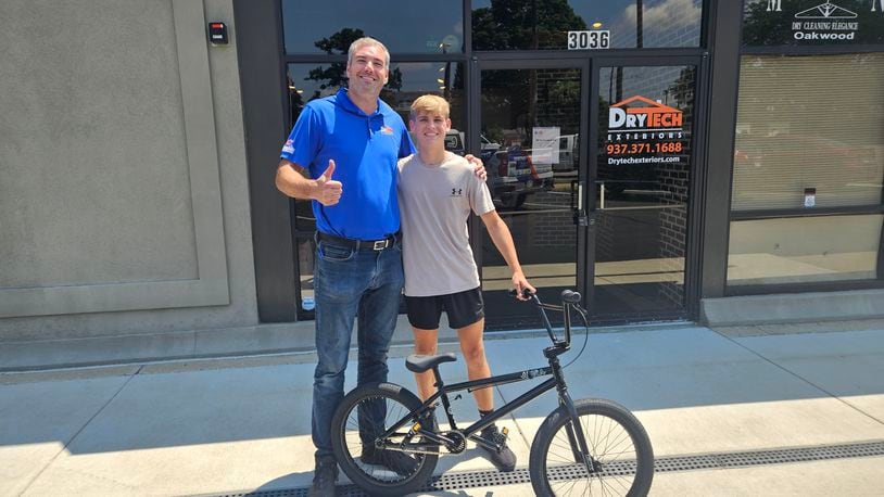 Brad Hosler, left. with Jonah Shreves and his new bike. JESSICA GRAUE/CONTRIBUTED