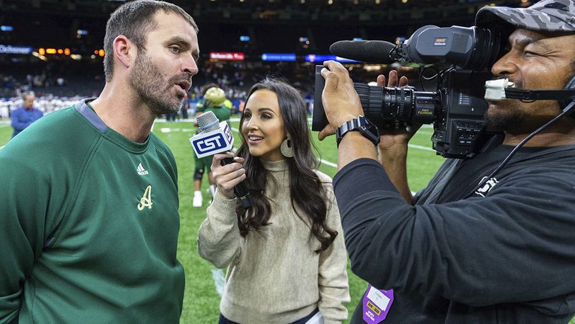 In this Dec. 14, 2019, photo Acadiana head coach Matt McCullough, left, speaks with Carley McCord, center, following a win over the Destrehan in the State Division 5A Championship football game in Lafayette, La. (Scott Clause/The Daily Advertiser via AP)