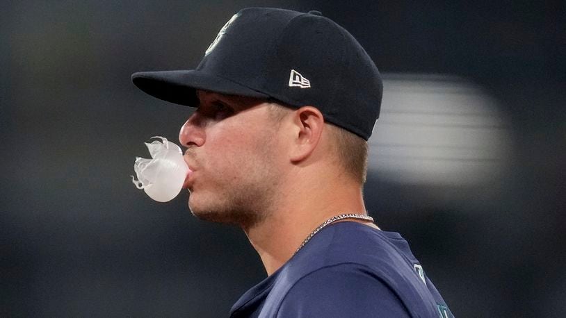 Seattle Mariners first baseman Ty France (23) blows a bubble during the seventh inning of a baseball game against the Los Angeles Angels in Anaheim, Calif., Thursday, July 11, 2024. (AP Photo/Eric Thayer)