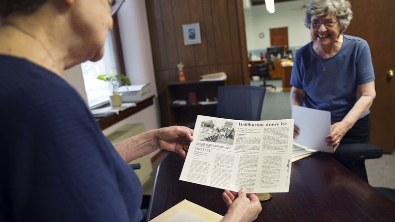 Benedictine sisters, Rose Marie Stallbaumer, left, and Barbara McCracken, right, look through corporate resolution archives and newspaper clippings at the Mount St. Scholastica monastery in Atchison, Kan., Tuesday, July 16, 2024. For the past two decades the community has participated in activist investing, a process in which they partner with other religious organizations to buy the stocks of companies they hope to positively influence. (AP Photo/Jessie Wardarski)