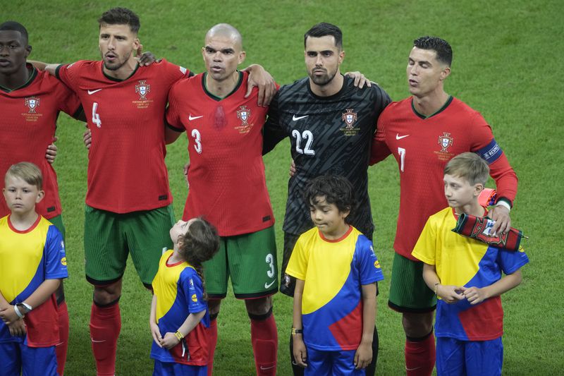 Portugal players singing the Portugal's National Anthem before a round of sixteen match between Portugal and Slovenia at the Euro 2024 soccer tournament in Frankfurt, Germany, Monday, July 1, 2024. (AP Photo/{Michael Probst)