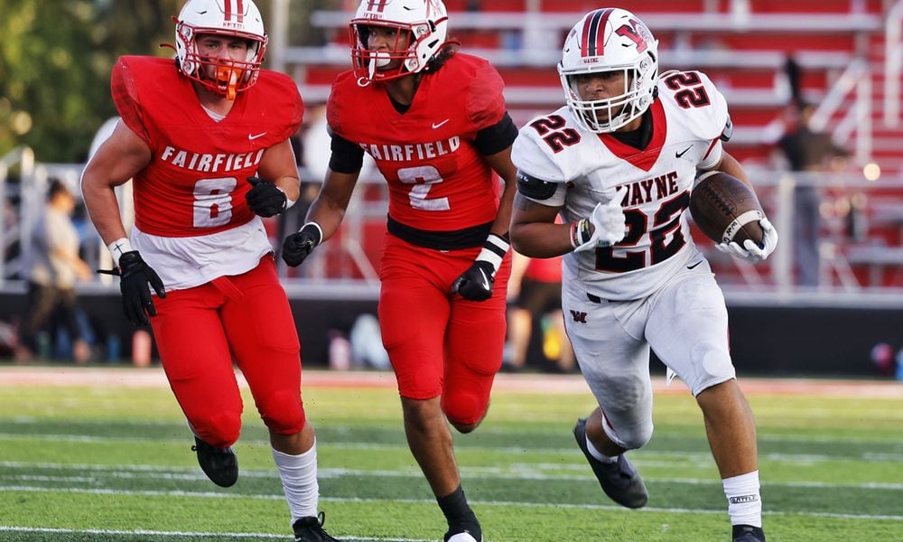 Wayne's Isaiah Thompson runs for yardage as Fairfield's Mason Gatto (8) and Kobe Lewis pursue during Friday night's season-opener at Fairfield. Nick Graham/STAFF