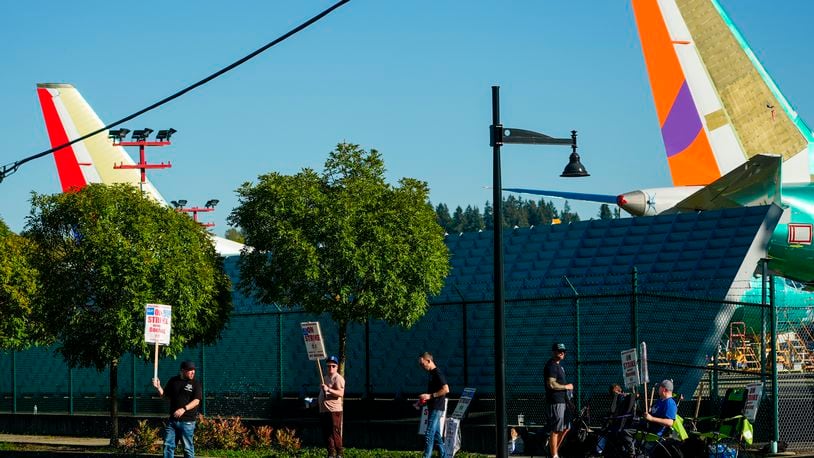 Boeing 737 Max aircrafts are seen behind fences as Boeing employees work the picket line while striking Tuesday, Sept. 24, 2024, next to the company's facilities in Renton, Wash. (AP Photo/Lindsey Wasson)