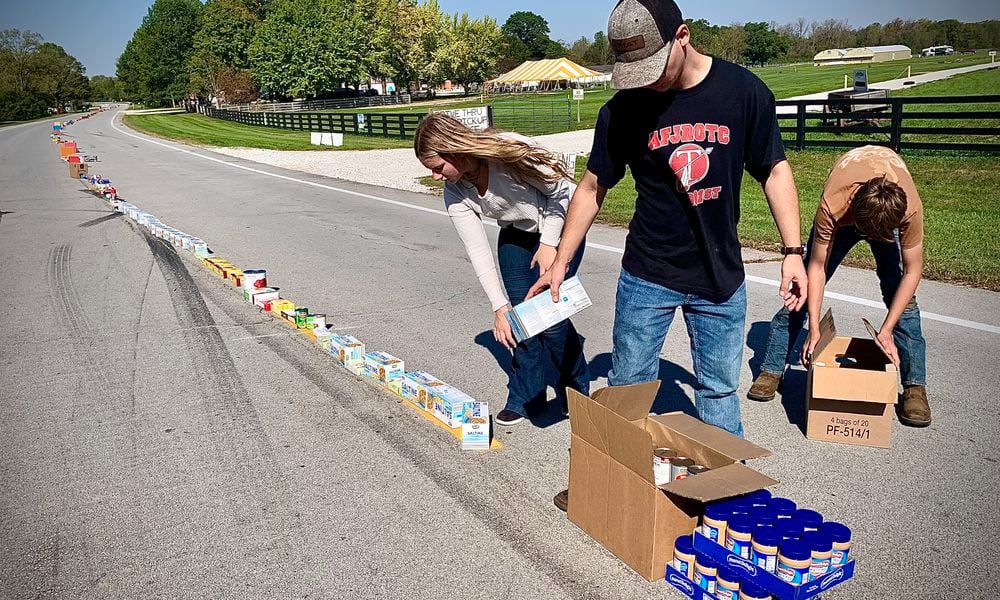 As part of the New Carlisle Heritage of Flight festival, residents, churches and businesses donated to the Mile of Food effort, stretching down Ohio 571 on Sunday morning, Oct. 6, 2024. The roughly 8,000 pounds of food collected reached 3/4 of a mile (the longest yet) and all will be given to the New Carlisle food bank. MARSHALL GORBY / STAFF