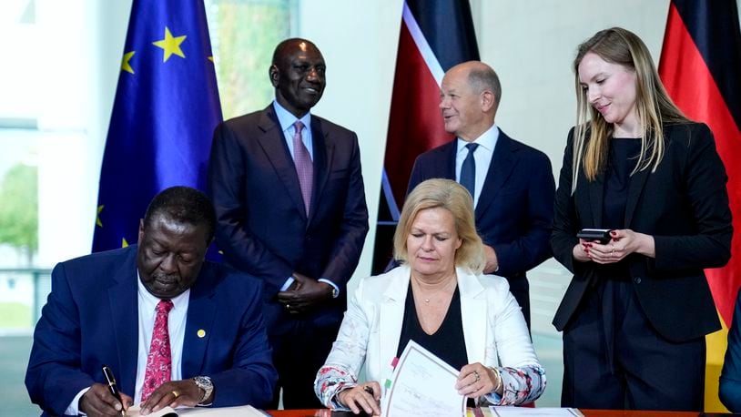 German Interior Minister Nancy Faeser, down right, signs a migration agreement with Kenyan's Prime Cabinet Secretary Musalia Mudavadi, left, as German Chancellor Olaf Scholz, centre behind, and Kenyan President William Ruto, left behind, at the chancellery in Berlin, Friday, Sept. 13, 2024. (AP Photo/Ebrahim Noroozi)