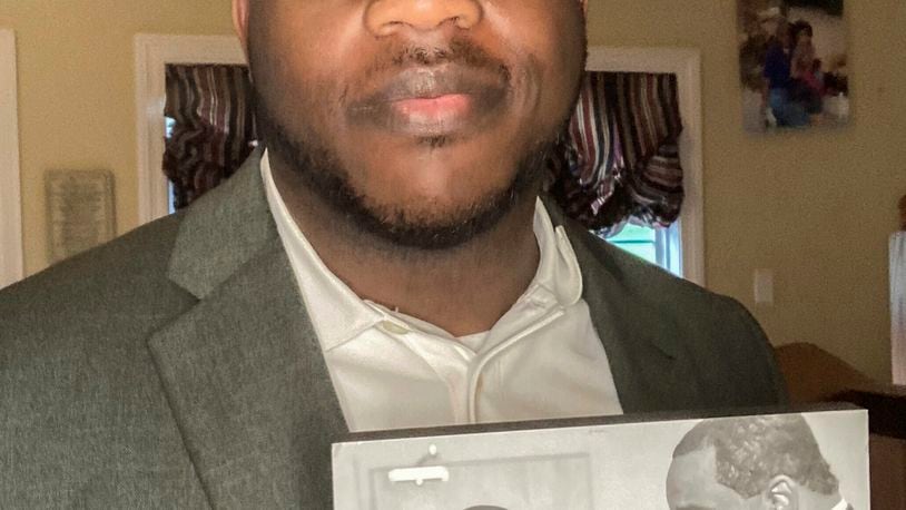 Darrell Dixon holds a photo of him and his dad, Darrell Dixon Sr., at his home in Hernando, Miss., on August 11, 2024. (Millicent Dixon via AP)