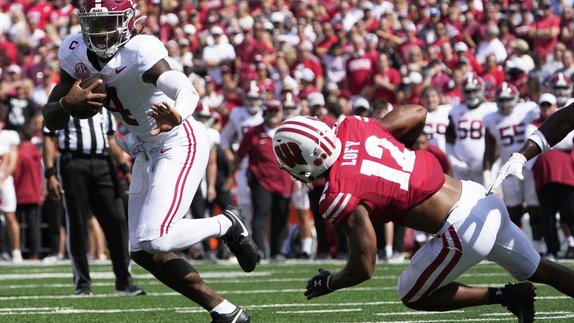 Alabama's Jalen Milroe (4) runs for a touchdown past Wisconsin's Max Lofy (12) runs past =tduring the first half of an NCAA college football game Saturday, Sept. 14, 2024, in Madison, Wis. (AP Photo/Morry Gash)