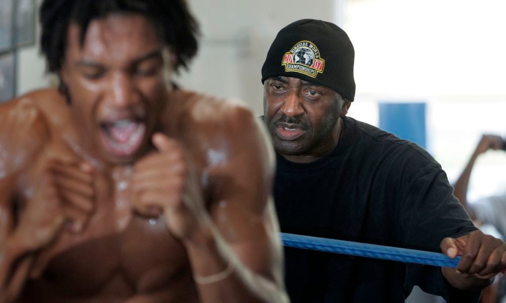 Trainer Ron Daniels watches intently from just beyond the ring ropes as boxer Miles Jackson works out back in 2010. Dayton Daily News file photo