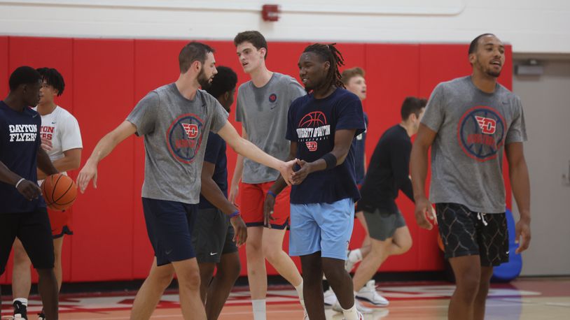 Dayton's Jacob Conner, left, slaps hands with Jaiun Simon during a summer practice on Monday, July 22, 2024, at the Cronin Center. David Jablonski/Staff